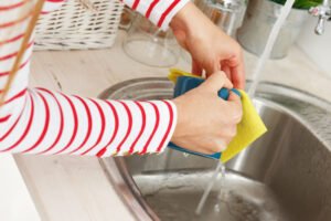 Kitchen. Woman washes tea cup